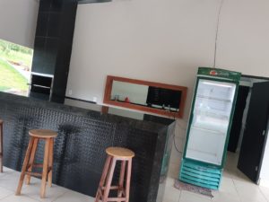 Espaço da currasqueira com cervejeira e acesso a cozinha